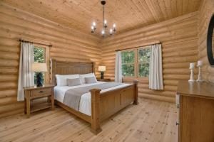 a bedroom with a bed in a log cabin at Fiddler Lake Resort - Deer 47 in Mille-Isles