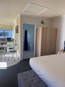 a bedroom with a bed and a table with a chair at Bay Cottages in Kaikoura