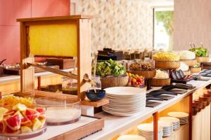 a buffet line with plates and bowls of food at HOTEL MYSTAYS Nagoya Sakae -Renewed in September 2026 All Guest Rooms & Breakfast in Nagoya