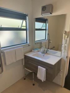 a bathroom with a sink and a large window at Bay Cottages in Kaikoura +32 photos