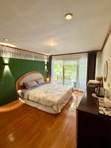 a bedroom with a bed and a green wall at Ban Mali Cafe & Riverside Stay in Ban Chang +71 photos