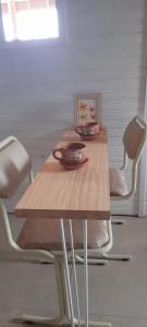 a wooden table with two chairs and a phone on it at El Tropezon cabaña in Resistencia +11 photos