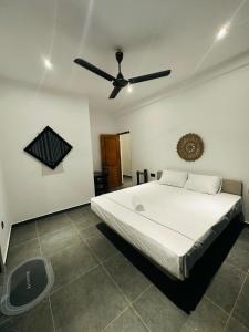 a bedroom with a bed and a ceiling fan at The Elm in Weligama