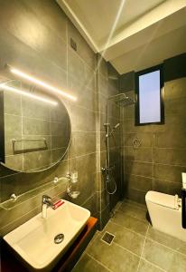a bathroom with a sink and a shower and a toilet at The Elm in Weligama