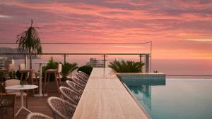 a balcony with a pool and tables and chairs at SOUMA Hotel, Vignette Collection by IHG in Lima
