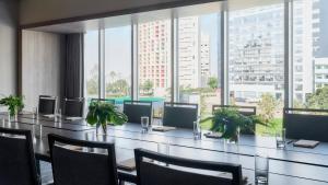 a conference room with a long table with chairs and windows at SOUMA Hotel, Vignette Collection by IHG in Lima +178 photos