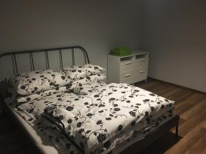 een bed met een zwart-witte deken en een dressoir bij Apartamenty Nad Potoczkiem in Ustroń