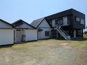 a black and white house with a garage at 海岸道路沿い 磯の宿 in Minamiboso