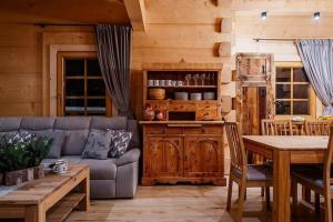 a living room with a couch and a table at A large mountain-style house with a spa area in Murzasichle