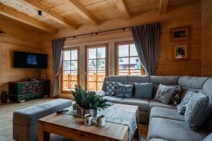 a living room with a couch and a table at A large mountain-style house with a spa area in Murzasichle