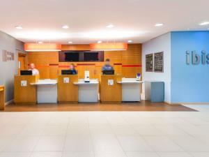 two people sitting at tables in a waiting room at ibis Fortaleza Praia de Iracema in Fortaleza