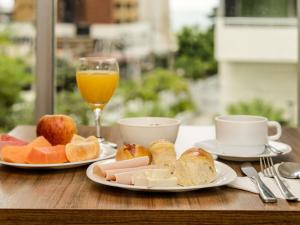 a table with two plates of food and a glass of orange juice at ibis Fortaleza Praia de Iracema in Fortaleza