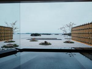a room with a large window looking out at the water at YOKI Matsushima in Matsushima