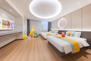 a bedroom with two beds and a play area at BOLE ZHEYU Hotel in Bole