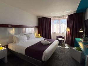a hotel room with a large bed and a desk at Mercure Strasbourg Centre in Strasbourg +96 photos