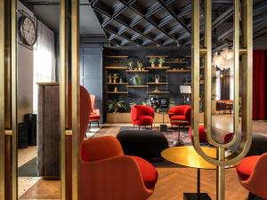 a lobby with red chairs and a table at Hotel Am Konzerthaus - MGallery Collection in Vienna