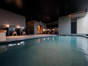 a swimming pool at night with chairs and a screen at YOKI Matsushima in Matsushima +71 photos