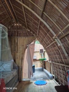 an inside view of a straw hut with a bed in it at DANG dang Balbago Beach in El Nido