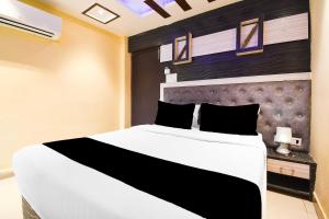a bedroom with a large white bed with a black headboard at Townhouse Hirak Road Dhanbad in Dhanbād