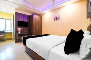 a hotel room with a bed and a television at Townhouse Hirak Road Dhanbad in Dhanbād