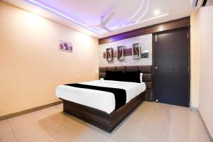 a bedroom with a bed with a black and white comforter at Townhouse Hirak Road Dhanbad in Dhanbād