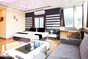 a hotel room with a bed and a couch at Townhouse Hirak Road Dhanbad in Dhanbād