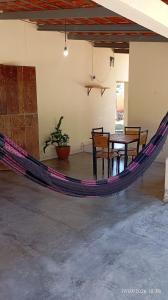 a hammock in a room with a table and chairs at Chalé Primavera in Cavalcante +16 photos