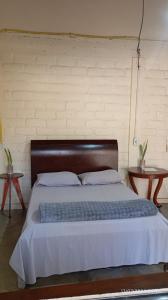 a bedroom with a large bed with a wooden headboard at Chalé Primavera in Cavalcante