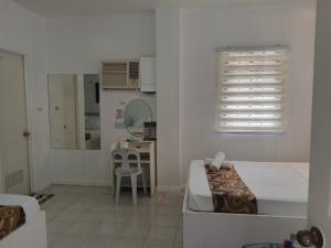 a bedroom with a bed and a table and a mirror at Villa Adela Pension House in Balamban