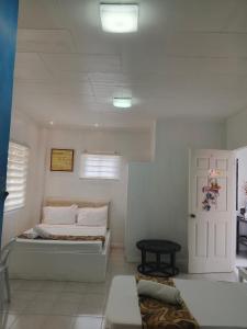 a white room with a bed and a door at Villa Adela Pension House in Balamban +27 photos