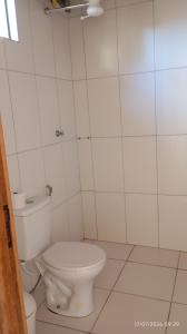 a bathroom with a white toilet in a room at Chalé Primavera in Cavalcante