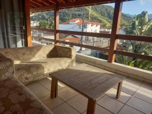a living room with a couch and a coffee table at JuquehyRoots AC vent em 4suítes 2 gelad salas banho térreos churrasq wifi jard filtro água estac terraço panorâm privativos piscina coletiva condo fech boa localizaçã SEM roupa cama mesa banho in Juquei