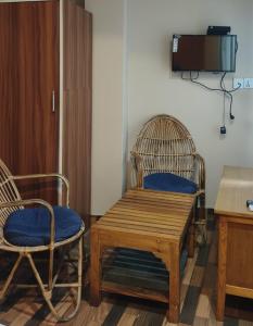 two chairs and a wooden bench in a room at Kathmandu Metro Boutique Hotel in Kathmandu