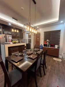 a dining room table with chairs and a kitchen at DonnRaqui's Hidden Zen in Iligan +39 photos