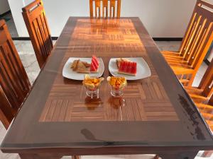 a table with two plates of food and fruit on it at RKM Hotel Uppuveli in Trincomalee +38 photos