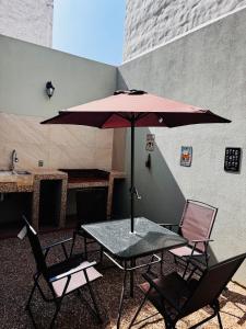 a table and chairs with an umbrella on a patio at Refugio urbano Saori in Guadalajara