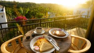 a wooden table with a plate of food on a balcony at Penida Cabins in Nusa Penida