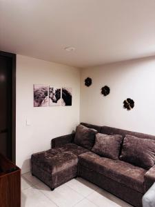 a living room with a brown couch and pictures on the wall at Refugio urbano Saori in Guadalajara