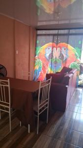 a living room with a table and two colorful birds at Villa La Patrona in Parrita