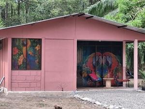 a pink shed with paintings on the side of it at Villa La Patrona in Parrita