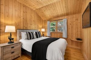 a bedroom with a bed in a wooden wall at Fiddler Lake Resort - Bear 25 in Mille-Isles