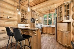 a kitchen with wooden cabinets and bar stools at Fiddler Lake Resort - Bear 25 in Mille-Isles
