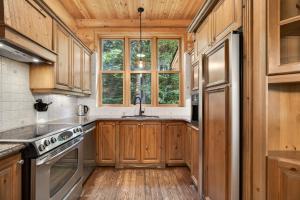 a kitchen with wooden cabinets and a sink and a window at Fiddler Lake Resort - Bear 25 in Mille-Isles +23 photos