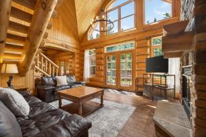 a living room with a couch and a tv in a cabin at Fiddler Lake Resort - Bear 25 in Mille-Isles