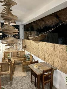 a room with tables and chairs and a hammock on the wall at Alona Garden Suites in Panglao Island
