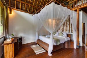 a bedroom with a bed with a canopy at Plaga Eco Village by Nabe Hospitality Management in Plaga