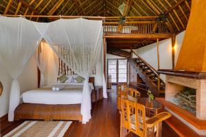 a bedroom with a bed with a mosquito net at Plaga Eco Village by Nabe Hospitality Management in Plaga