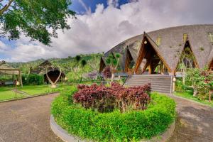 a building with a garden in front of it at Plaga Eco Village by Nabe Hospitality Management in Plaga