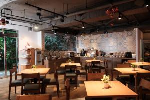 a restaurant with wooden tables and chairs and a kitchen at Citizen Hotel in Taipei +21 photos