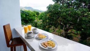 a table with two plates of breakfast food and orange juice at Penida Cabins in Nusa Penida +58 photos